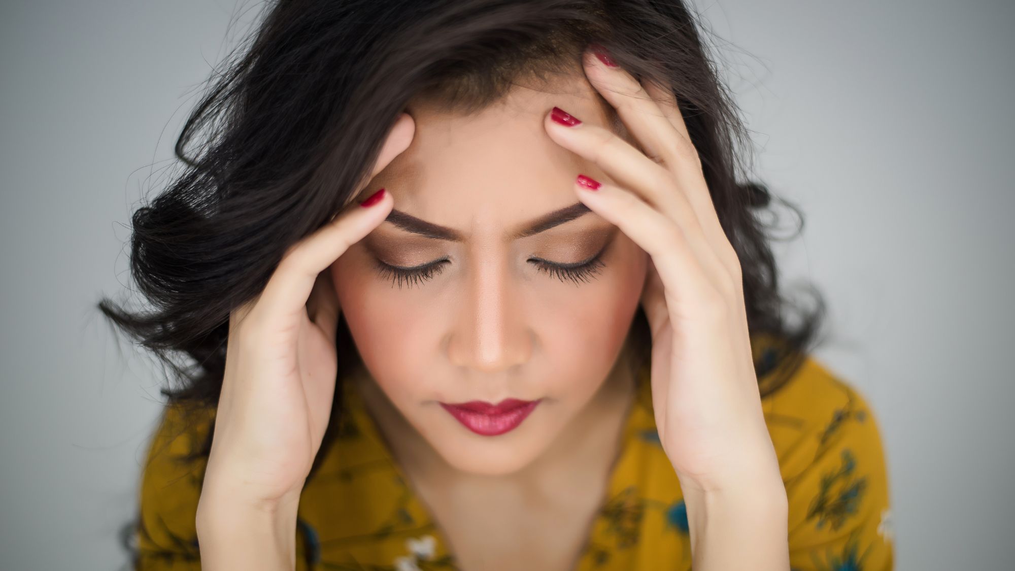 A woman looking stressed due to rough skin and skin care issues
